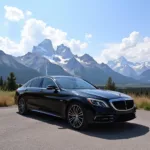 Luxury Black Car Against Jackson Hole Mountain Backdrop