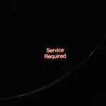 Car dashboard displaying service required light