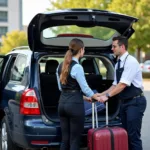 Car service driver assisting a passenger with luggage