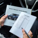 Car owner reviewing their owner's manual and service booklet for service history