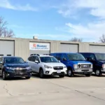 A fleet of modern Bluebird cars parked in a row, ready for service.