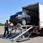 Car being loaded onto a car carrier truck for transport