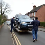 Car collection service in the UK loading a vehicle onto a transporter.