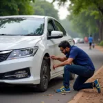 Car with a flat tire on the side of the road in Noida