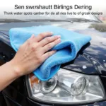 Person drying a car with a microfiber towel after washing