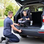 Certified technician fitting a baby car seat in a car