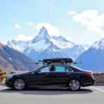 Geneva to Chamonix Car Service: A black luxury sedan parked amidst the snow-capped Alps, with ski equipment loaded in the trunk.