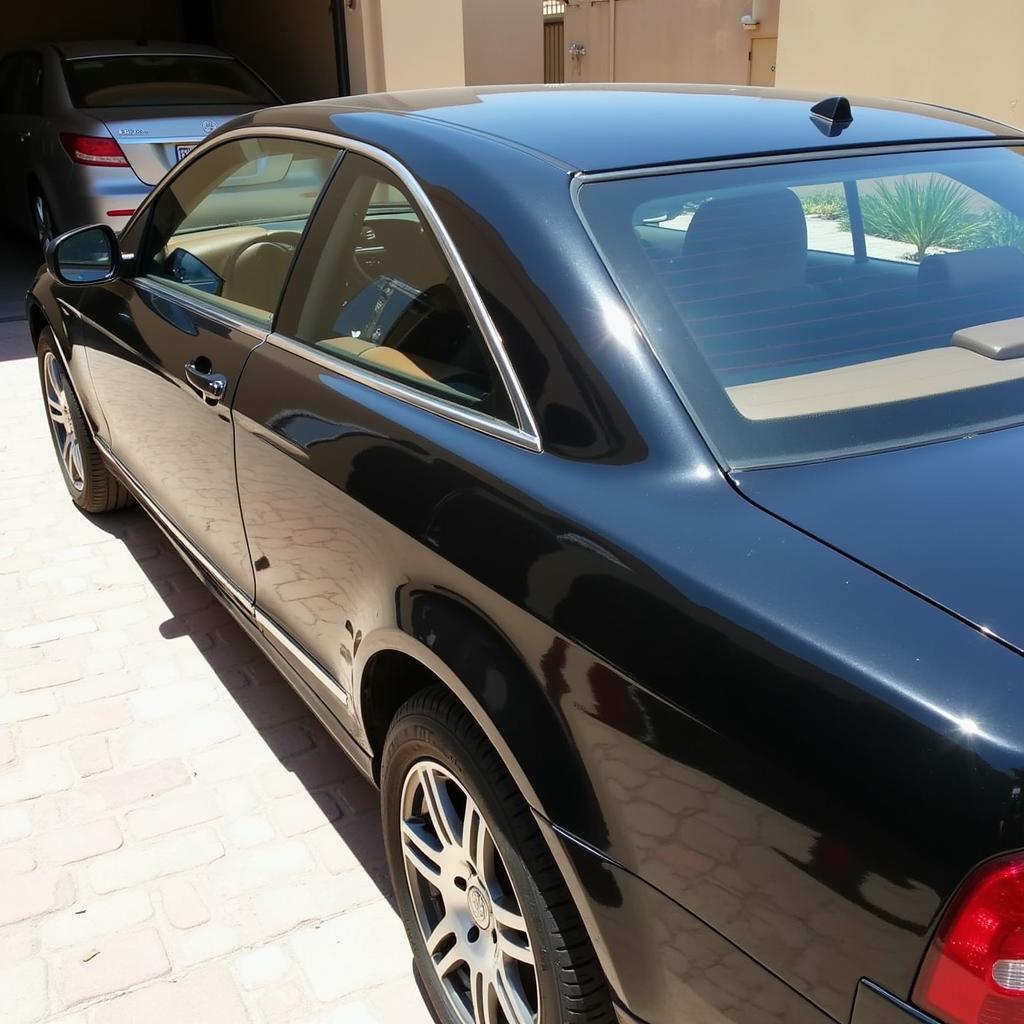 A sparkling clean car parked in front of a Kuwaiti home, after a professional car cleaning home service